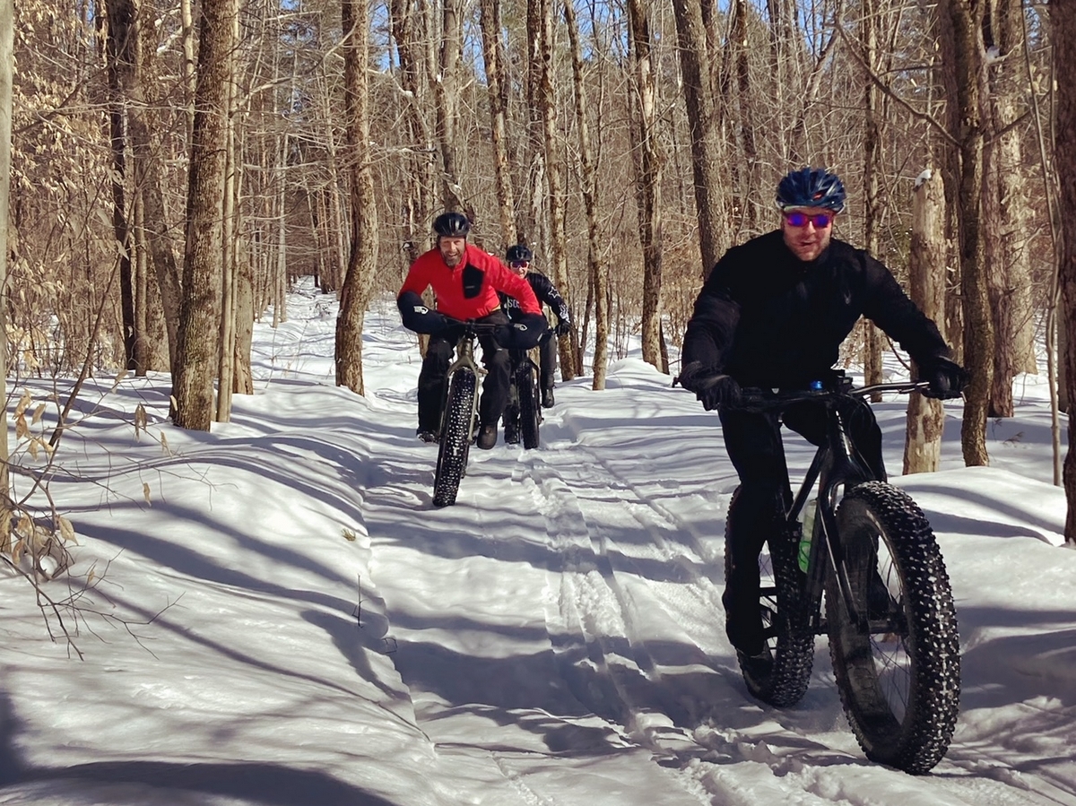 A group of people riding bikes in the snow