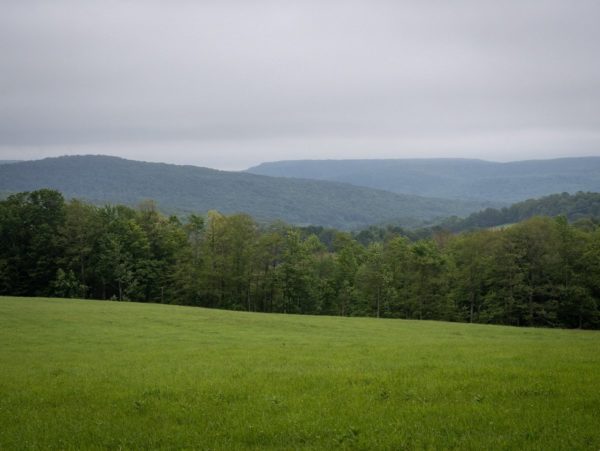 An open field with a view of green hills
