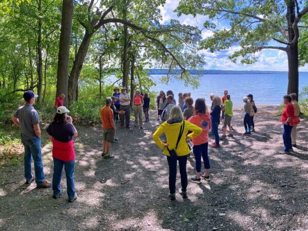 A group of people standing on the shore of a lake