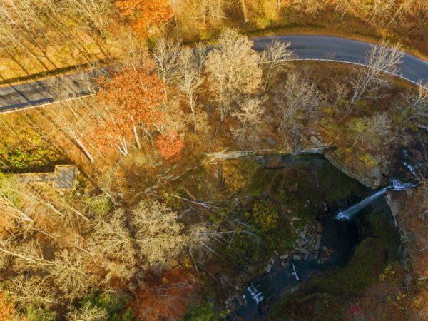 An aerial view of a waterfall and wooden viewing platform