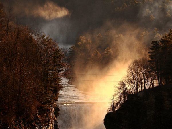 A misty waterfall illuminated by sunset