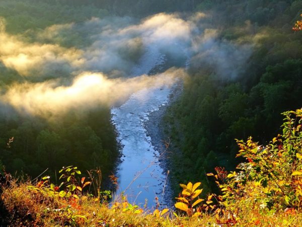 An aerial view of the gorge and river with misty clouds