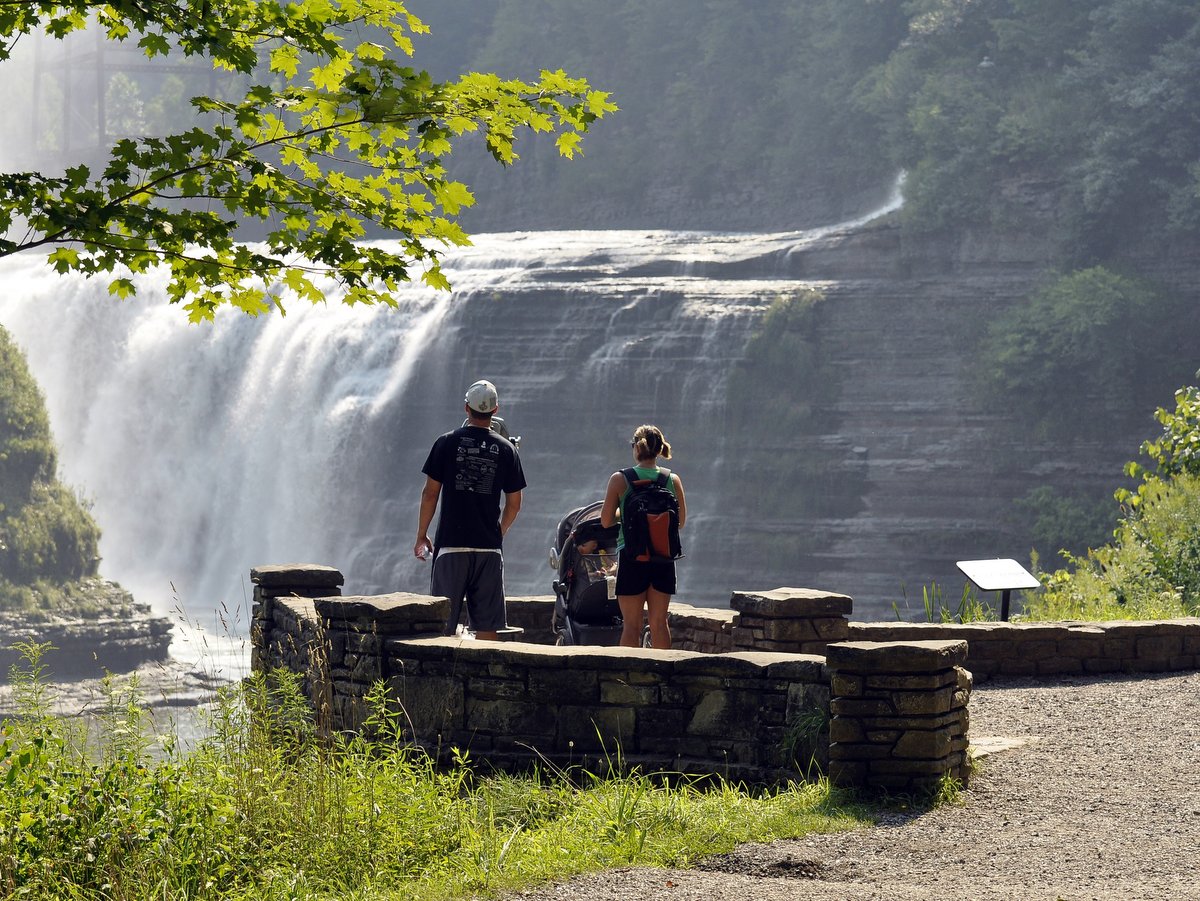 Two people standing in front of a large waterfall