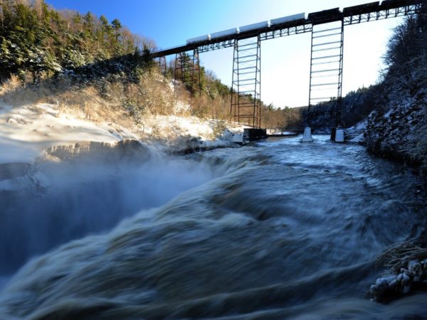 A railroad bridge high above a rushing river