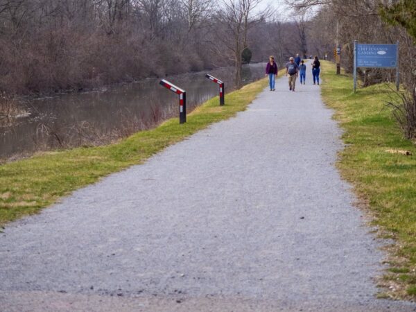 People walking on a flat flat by a canal