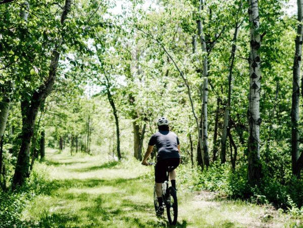 A person biking on a grassy path