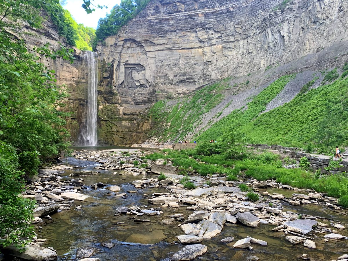 A gorge with a rocky creek bed and long waterfall