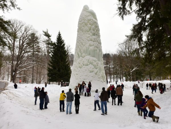 A frozen water fountain and people in winter