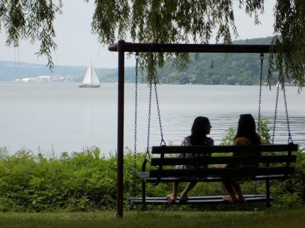 Two people sitting on a bench with a lakeview