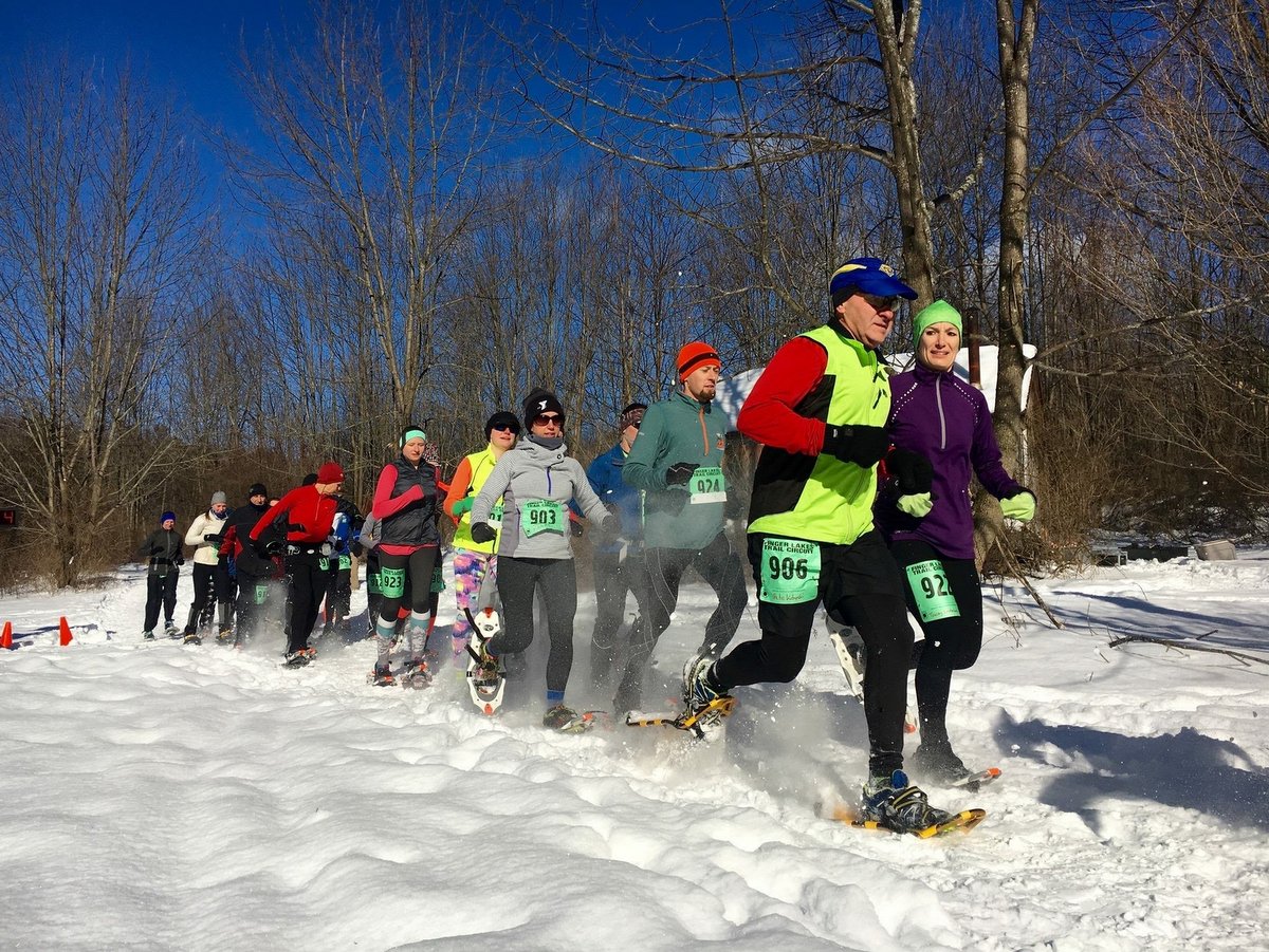 A group of people running in snowhoes