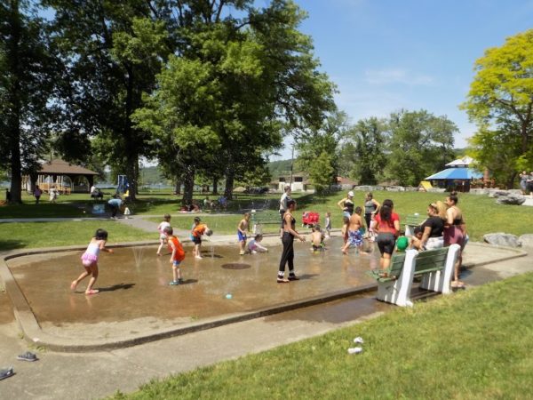 Families playing in a park fountain